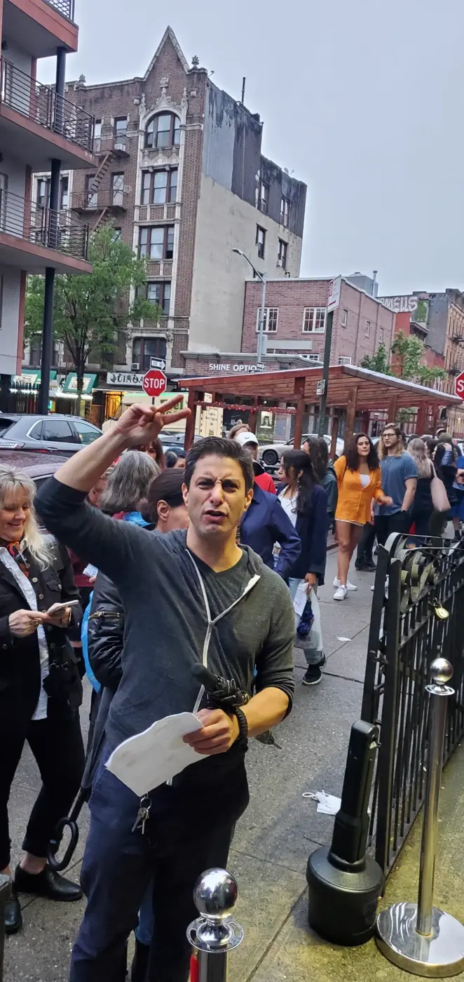 Host checking in the crowd waiting outside before a comedy show