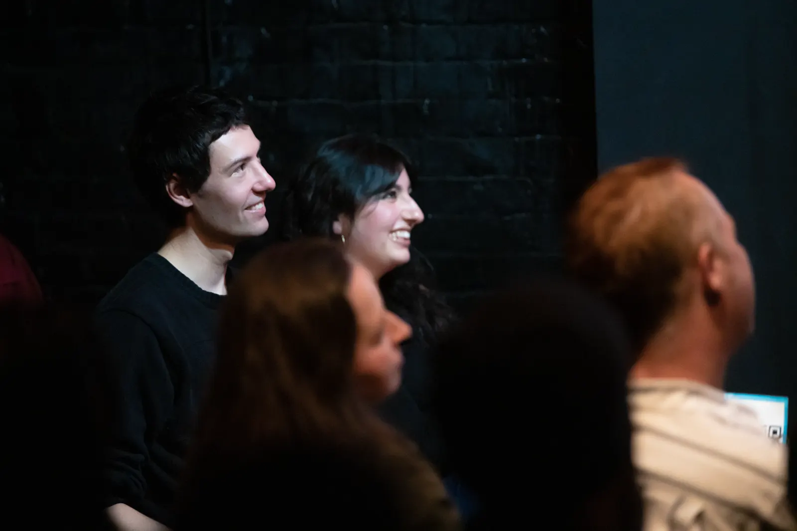 Packed crowd watching stand-up at a Funny People At comedy show