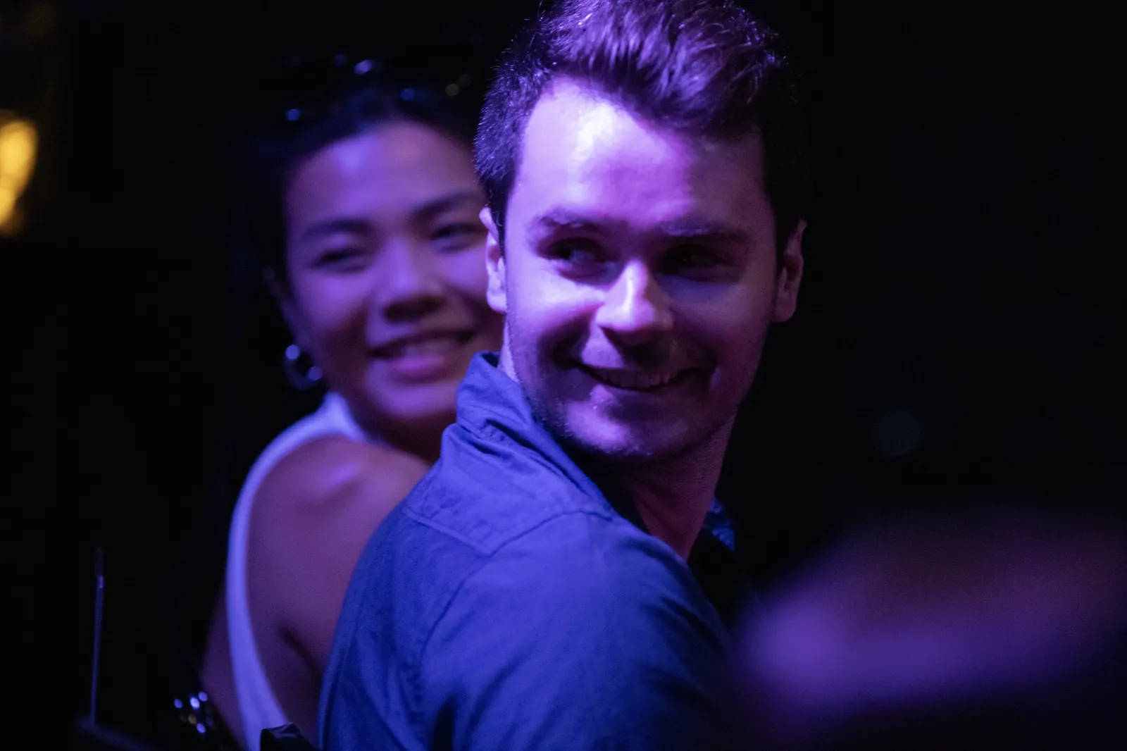 Two audience members smiling in the crowd during a stand-up comedy show